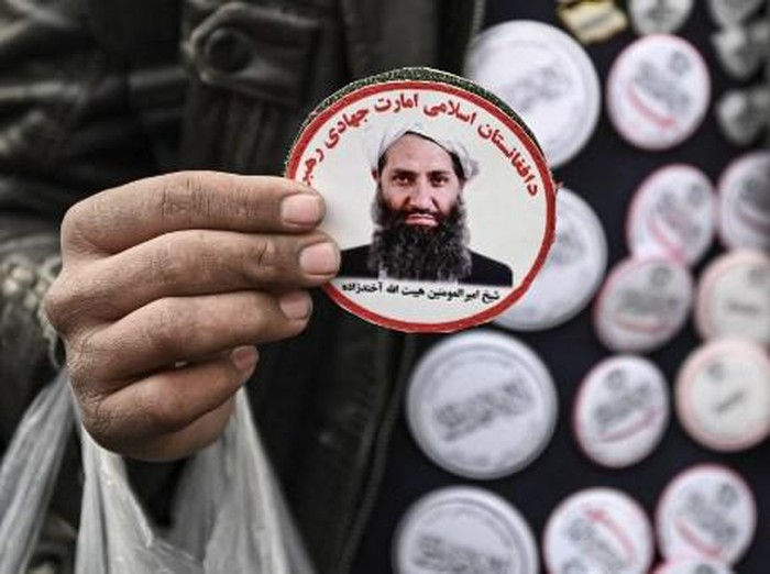 A man sells stickers picturing Taliban supreme leader Haibatullah Akhundzada at market in Kabul on December 26, 2021. (Photo by Mohd RASFAN / AFP)