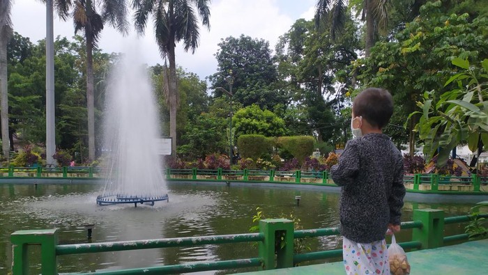 Ilustrasi anak melihat air mancur  saat berwisata di Taman Beringin, Medan.