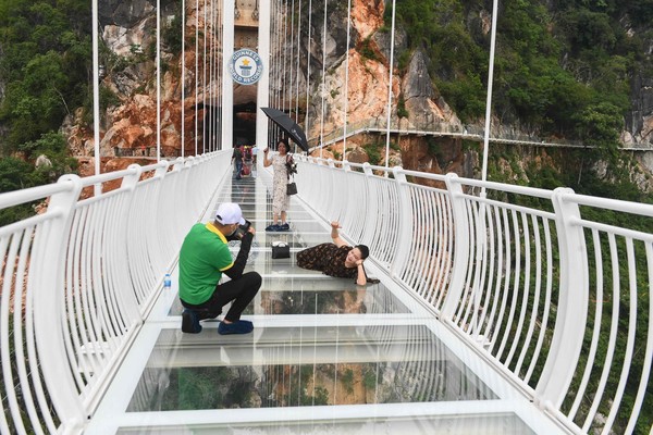 Melalui lantai kaca pada jembatan, wisatawan dapat melihat pemandangan hutan di bawahnya danberfoto dengan pemandangan cantik. Kendati demikian, berjalan di atasnya sungguh memacu adrenalin.Foto: AFP
