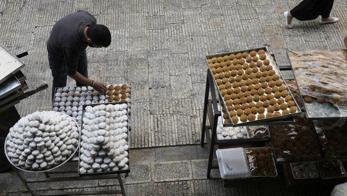 Palestinians prepare traditional Eid sweets before Eid al-Fitr at a shop inside the old city of Nablus, the Israeli-occupied West Bank, April 27, 2022. Picture taken April 27, 2022. REUTERS/Raneen Sawafta
