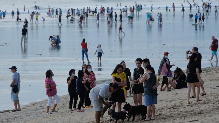 Wisatawan menikmati liburan Hari Raya Idul Fitri 1443 H di Pantai Kuta, Badung, Bali, Senin (2/5/2022). Objek wisata tersebut kembali ramai dikunjungi wisatawan pada saat liburan Hari Raya Idul Fitri 1443 H setelah dua tahun sebelumnya sempat mengalami penurunan kunjungan wisatawan akibat pandemi COVID-19. ANTARA FOTO/Nyoman Hendra Wibowo/nym.
