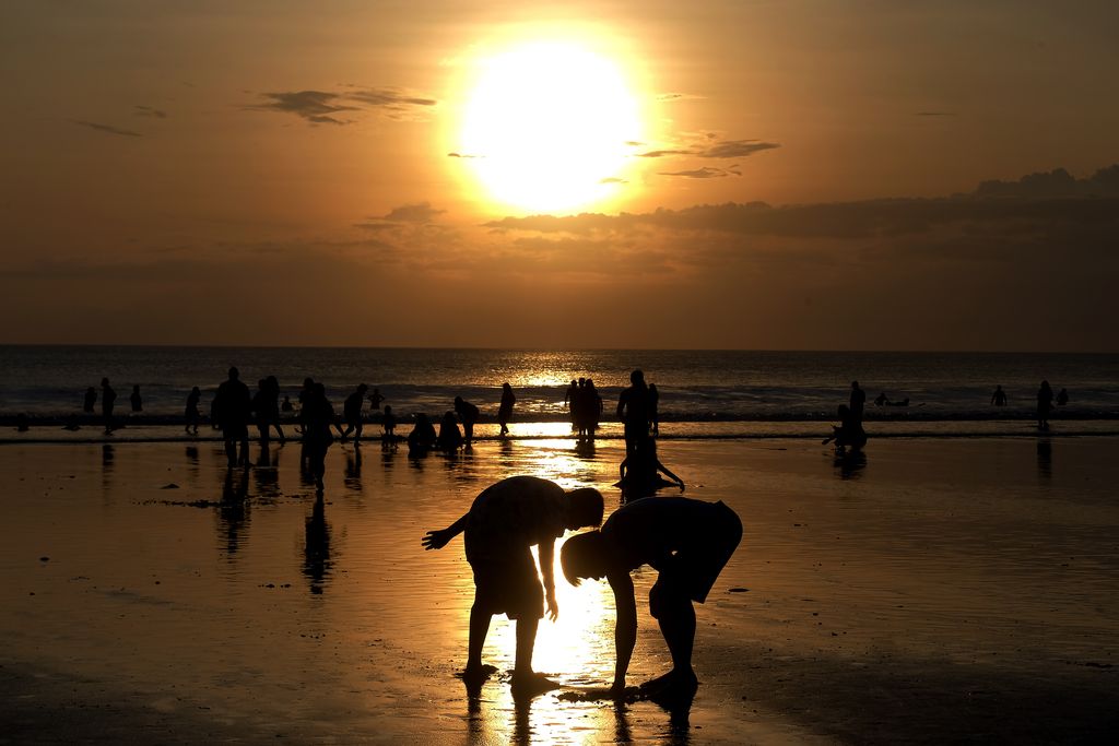 Wisatawan menikmati liburan Hari Raya Idul Fitri 1443 H di Pantai Kuta, Badung, Bali, Senin (2/5/2022). Objek wisata tersebut kembali ramai dikunjungi wisatawan pada saat liburan Hari Raya Idul Fitri 1443 H setelah dua tahun sebelumnya sempat mengalami penurunan kunjungan wisatawan akibat pandemi COVID-19. ANTARA FOTO/Nyoman Hendra Wibowo/nym.