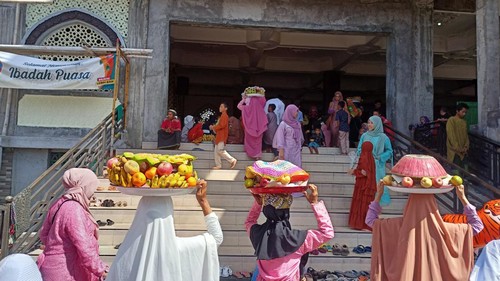 sejumlah warga Kecicang Islam saat membawa sajian tradisi menekan ke masjid