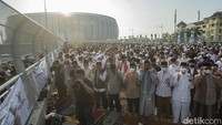 Warga yang hendak salat Id masih berdatangan ke JIS. Sebagai dari mereka terlihat mencari-cari tempat untuk salat karena lokasi yang sudah penuh. 
