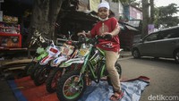 Seorang anak menjajal motor mainan yang dipajang di salah satu kios mainan di Pasar Gembrong.