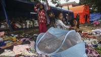 Di depan tenda, para anak-anak tetap ceria bermain di tumpukan baju - baju bekas layak pakai, seolah tidak terjadi apa-apa. Mereka memanfaatkan pakaian seadanya untuk sekedar bermain dengan anak-anak sebayanya.
