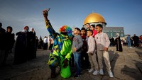 Seorang badut berswafoto dengan anak Palestina setelah salat Idul Fitri.