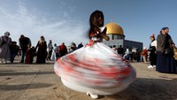Seorang anak gadis Palestina menari dengan ceria setelah salat Idul Fitri.