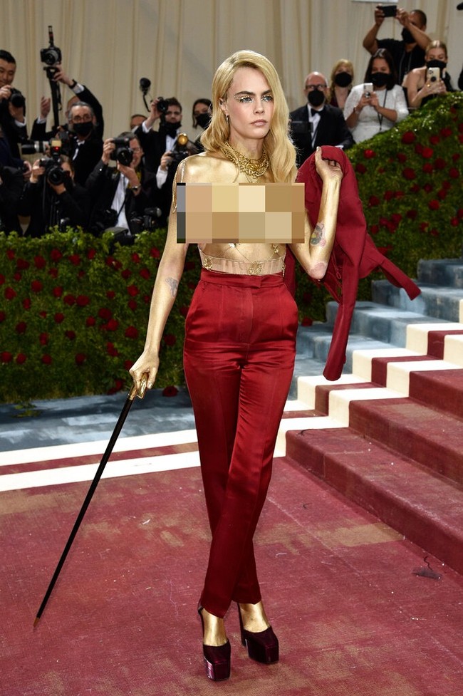 Saat berpose di hadapan fotografer, Cara Delevingne yang awalnya berbusana lengkap tiba-tiba melepas blazer tersebut di karpet merah. Tak ada dalaman yang menutupi tubuh atasnya alias topless. (Foto: Evan Agostini/Invision/AP)