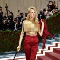 Saat berpose di hadapan fotografer, Cara Delevingne yang awalnya berbusana lengkap tiba-tiba melepas blazer tersebut di karpet merah. Tak ada dalaman yang menutupi tubuh atasnya alias topless. (Foto: Evan Agostini/Invision/AP)