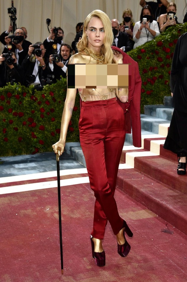 Saat tampil topless, terungkap Cara Delevingne menjelma sebagai manusia emas. Tubuh bagian atasnya hanya dibalur cat berwarna emas.  (Foto: Evan Agostini/Invision/AP)