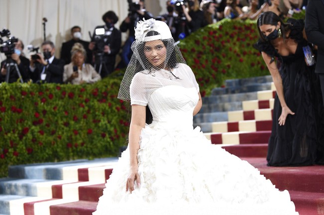 Bak pengantin, Kylie Jenner memakai gaun putih bersiluet ball-gown yang megar dari Off-White. Topi baseball hadir sebagai pengganti headpieace yang unik. (Foto: Evan Agostini/Invision/AP)