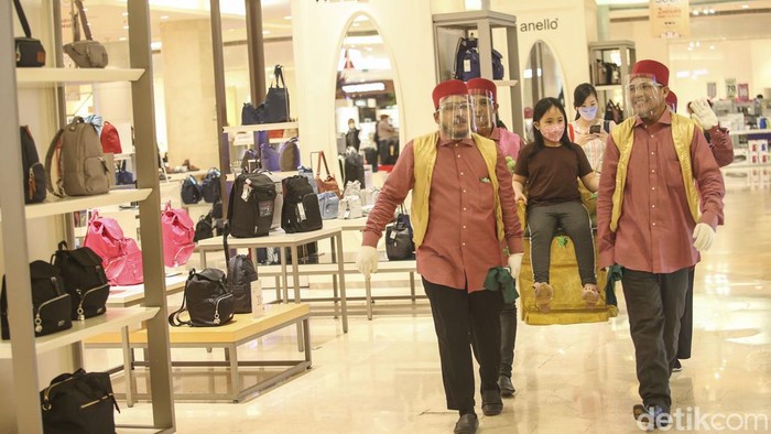 Seorang anak menaiki tandu di Lotte Shopping Avenue, Jakarta, Selasa (3/5/2022). Libur hari raya Lebaran digunakan keluarga untuk berkumpul bersama keluarga salah satunya dengan berkunjung ke pusat perbelanjaan.
