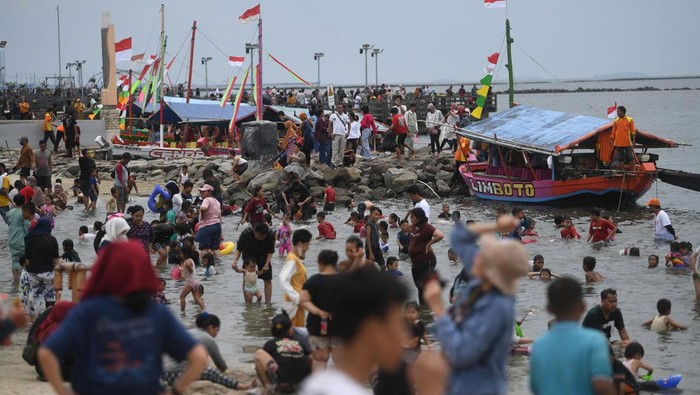 Petugas memantau pengunjung dalam upaya membantu seorang anak menemukan orang tuanya di kawasan Pantai Ancol, Taman Impian Jaya Ancol, Jakarta, Selasa (3/5/2022). Objek wisata tersebut kembali ramai dikunjungi wisatawan pada saat liburan Hari Raya Idul Fitri 1443 H setelah dua tahun sebelumnya sempat mengalami penurunan kunjungan wisatawan akibat pandemi COVID-19. ANTARA FOTO/Akbar Nugroho Gumay/nym.