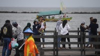 Pengunjung berswafoto di kawasan Pantai Ancol, Taman Impian Jaya Ancol, Jakarta.
