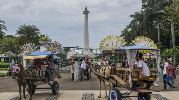 Warga naik delman di kawasan luar Monumen Nasional (Monas), Jakarta.