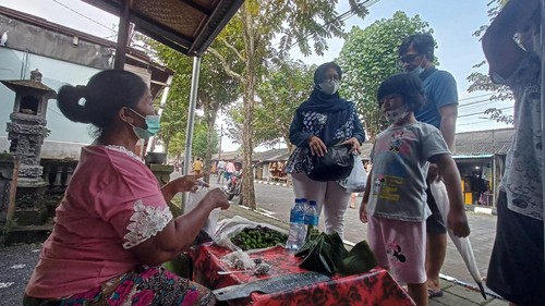 Sulotri, salah satu pedagang kue Klepon di objek wisata Tanah Lot, saat meladeni pembelinya.