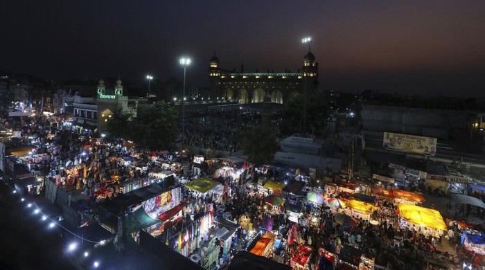 Indians shop ahead of Eid al-Fitr in front of Mecca Mosque in Hyderabad, India, Monday, May 2, 2022. Eid al-Fitr marks the end of the holy fasting month of Ramadan. (AP Photo/Mahesh Kumar A.)