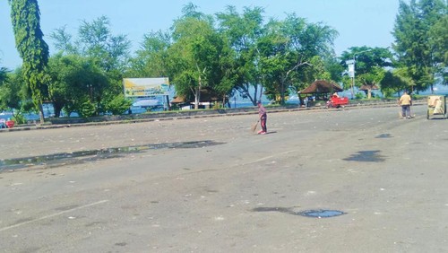 Petugas kebersihan Dinas Lingkungan Hidup Jembrana, membersihkan sampah pasca antrean arus mudik, di terminal manuver Gilimanuk, Senin (2/5/2022) (I Ketut Suardika/detikBali).