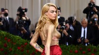 Separuh tubuh Cara Delevingne tampak dicat emas. (Foto: Getty Images via AFP/DIMITRIOS KAMBOURIS)  