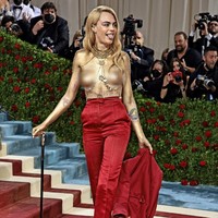Model dan aktris Cara Delevingne menjelma sebagai manusia emas. Tubuhnya dibungkus setelan merah Dior Haute Couture yang kemudian ia buka bagian blazer bergaya militernya dan tampil topless di sepanjang karpet merah. (Foto: Getty Images via AFP/DIMITRIOS KAMBOURIS)