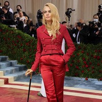Setelan merah dari Dior Haute Coutre dengan blazer bertema militer membungkus tubuh model dan aktris 29 tahun itu. Ia lalu melengkapi gayanya dengan platform heels dan tongkat. (Foto: Getty Images via AFP/DIMITRIOS KAMBOURIS)
