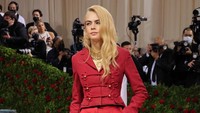 Cara Delevingne awalya tampil dengan busana rancangan Dior berwarna merah dari atas hingga ujung kaki. (Foto: Getty Images via AFP/DIMITRIOS KAMBOURIS)  