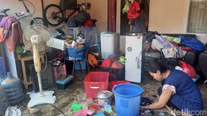 Warga di Ciputat, Tangsel, membersihkan rumahnya usai banjir surut (Khairul/detikcom)