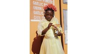Wanita yang memakai mahkota bunga ini ada di Afrika Selatan. Terlihat ia sedang menikmati snack kentang populer di sana yaitu Simba Chippies. Foto ini merupakan karya Marguerite Oelfose. Foto: Marguerite Oelfose