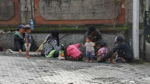 Beberapa gepeng sedang beristirahat di depan toko di Ubud, belum lama ini.