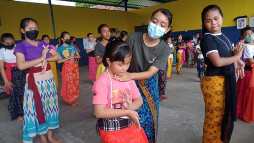 Para mahasiswa HIndu mengajarkan para siswa SD menari.