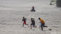Pengunjung bermain di hamparan pasir.