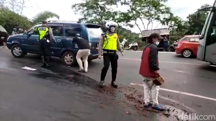 Polisi dan warga berusaha membersihkan tumpahan solar di tanjakan Gentong Tasikmalaya.