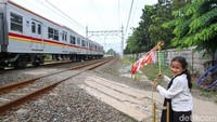 Khofifah dan Adiknya Lala, menjaga palang pintu perlintasan kereta api di kawasan Poris, Tangerang.