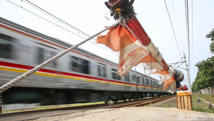 Khofifah dan Adiknya Lala, menjaga palang pintu perlintasan kereta api di kawasan Poris, Tangerang, Rabu (4/5/2022). Khofifah dan Lala kerap membantu menjaga palang perlintasan pintu kereta api ketika ayahnya atau penjaga lainnya sedang beristirahat atau berhalangan menjaga palang pintu perlintasan tersebut.