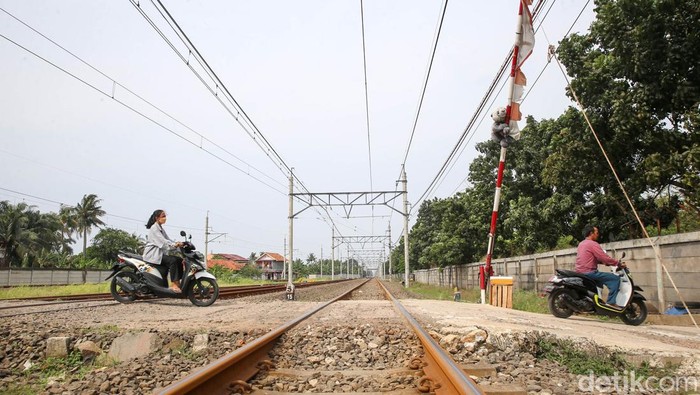 Khofifah dan Adiknya Lala, menjaga palang pintu perlintasan kereta api di kawasan Poris, Tangerang, Rabu (4/5/2022). Khofifah dan Lala kerap membantu menjaga palang perlintasan pintu kereta api ketika ayahnya atau penjaga lainnya sedang beristirahat atau berhalangan menjaga palang pintu perlintasan tersebut.