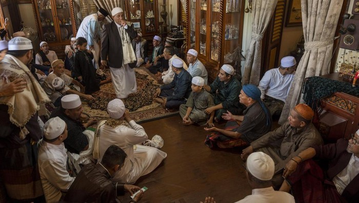 Sejumlah warga berebut uang yang dibagikan pada tradisi Lebaran Arab atau Iwwadh di Palu, Sulawesi Tengah, Selasa (3/5/2022). Tradisi yang telah diwarisi sejak puluhan tahun lalu itu digelar oleh warga muslim keturunan Arab yang tinggal di Palu dan biasanya dilakukan setiap hari kedua Idul Fitri dengan bersilaturahim dari rumah ke rumah untuk mendoakan pemilik rumah serta membagi-bagikan uang. ANTARA FOTO/Basri Marzuki/nym.