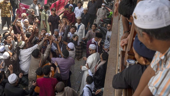 Sejumlah warga berebut uang yang dibagikan pada tradisi Lebaran Arab atau Iwwadh di Palu, Sulawesi Tengah, Selasa (3/5/2022). Tradisi yang telah diwarisi sejak puluhan tahun lalu itu digelar oleh warga muslim keturunan Arab yang tinggal di Palu dan biasanya dilakukan setiap hari kedua Idul Fitri dengan bersilaturahim dari rumah ke rumah untuk mendoakan pemilik rumah serta membagi-bagikan uang. ANTARA FOTO/Basri Marzuki/nym.