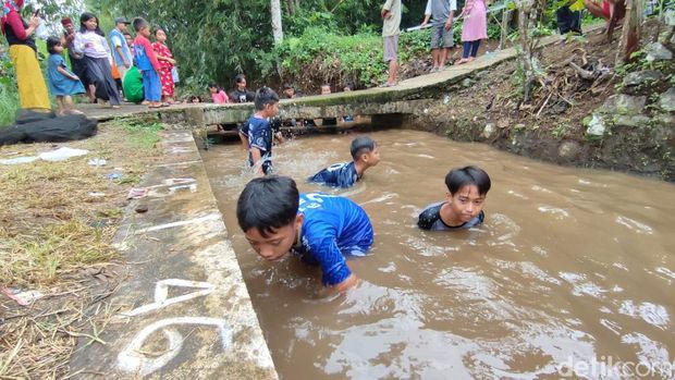 Tradisi Ngobeng atau mengambil ikan dengan tangan