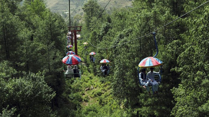 Tourists enjoy riding chairlifts at the hill resort town of Murree, during the first day of Eid al-Fitr near Islamabad, Pakistan, Tuesday, May 3, 2022. (AP Photo/Rahmat Gul)