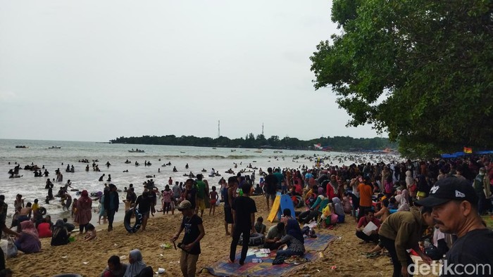 H+2 Lebaran para pengunjung mulai padati Pantai Carita Pandeglang. Terlihat antusias warga sedang berekreasi air di pantai, Rabu, 4/5/2022.