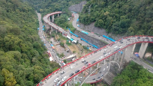Seiring waktu berjalan, keramaian dan kepadatan meningkat karena pertumbuhan ekonomi. Kondisi jalan dengan tanjakan curam dan tikungan tajam berbahaya bagi penggunanya karena banyak truk besar dengan muatan berat gagal menanjak. Selain itu, waktu tempuh jadi makin panjang. Lalu lintas kendaraan juga padat karena lajur masih sempit, sehingga pengendara kesulitan mendahului kendaraan di depannya. Kementerian Pekerjaan Umum membangun Jembatan Kelok Sembilan pada 2003. (ANTARA FOTO/Iggoy el Fitra) Seiring waktu berjalan, keramaian dan kepadatan meningkat karena pertumbuhan ekonomi. Kondisi jalan dengan tanjakan curam dan tikungan tajam berbahaya bagi penggunanya karena banyak truk besar dengan muatan berat gagal menanjak. Selain itu, waktu tempuh jadi makin panjang. Lalu lintas kendaraan juga padat karena lajur masih sempit, sehingga pengendara kesulitan mendahului kendaraan di depannya. Kementerian Pekerjaan Umum membangun Jembatan Kelok Sembilan pada 2003. (ANTARA FOTO/Iggoy el Fitra)