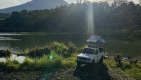 Wisatawan bermain membaca buku saat mengikuti trip wisata campervan di Lereng Gunung Merapi, Magelang, Jawa Tengah. Buat kamu yang ingin merasakan sensasinya, nggak perlu harus punya kok, karena sudah ada banyak jasa penyewaan campervan di Indonesia, salah satunya Ombak Selatan. Dok. Ombak Selatan