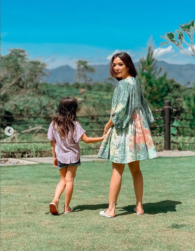 Pada beberapa foto napak tilas di kampung halaman yang diunggah di Instagram, tampak wanita 31 tahun ini mengenakan mini dress bermotif tie dye. Foto: Dok. Instagram/gisel_la