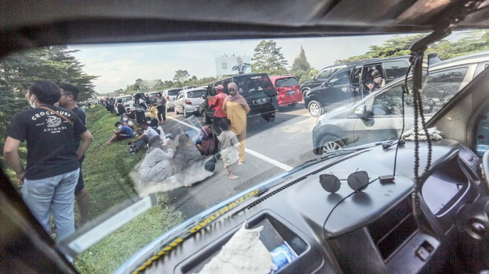 Sejumlah wisatawan keluar dari kendaraannya saat terjebak kemacetan akibat buka tutup jalan Puncak, Gadog, Kabupaten Bogor, Jawa Barat, Kamis (5/5/2022). Polda Jawa Barat menyebutkan puncak liburan Lebaran di kawasan wisata Jawa Barat diperkirakan terjadi pada Jumat {6/5) dan Sabtu (7/5). ANTARA FOTO/Yulius Satria Wijaya/nym.