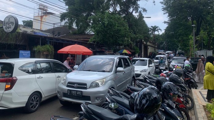 Jalan di depan pintu selatan Tebet Eco Park di Jakarta Selatan (Jaksel) macet imbas sejumlah mobil pribadi parkir di bahu jalan. Sementara separuh jalan tersebut dipadati parkiran motor, Kamis (5/5/2022).