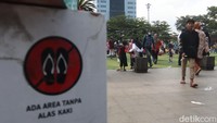 Padahal rambu atau tanda dilarang menggunakan alas kaki saat menginjak rumput jelas terpampang.