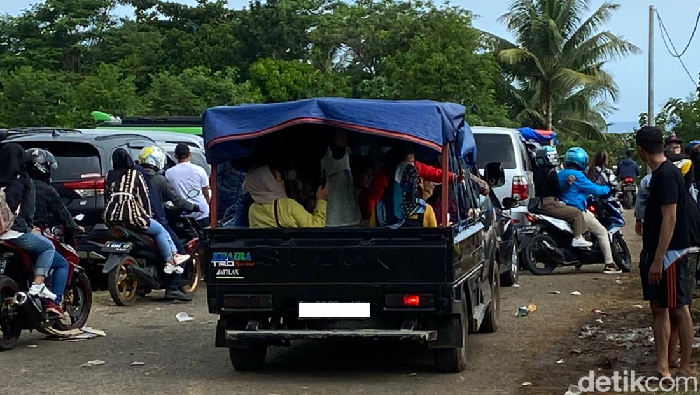Warga Liburan Naik Mobil Bak Terbuka sampai Atap