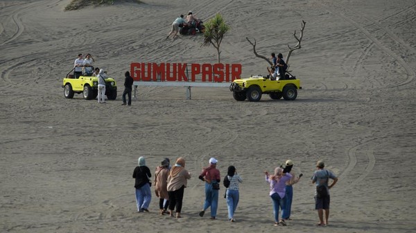 Pengunjung berwisata di Gumuk Pasir, Parangkusumo, Bantul, D.I Yogyakarta, Rabu (4/5/2022).   
