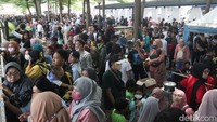 Ada yang duduk di kursi taman yang ada di atas trotoar, ada juga warga yang mencicipi makanan yang dijual oleh para pedagang kuliner di luar kawasan Alun-alun Bandung.